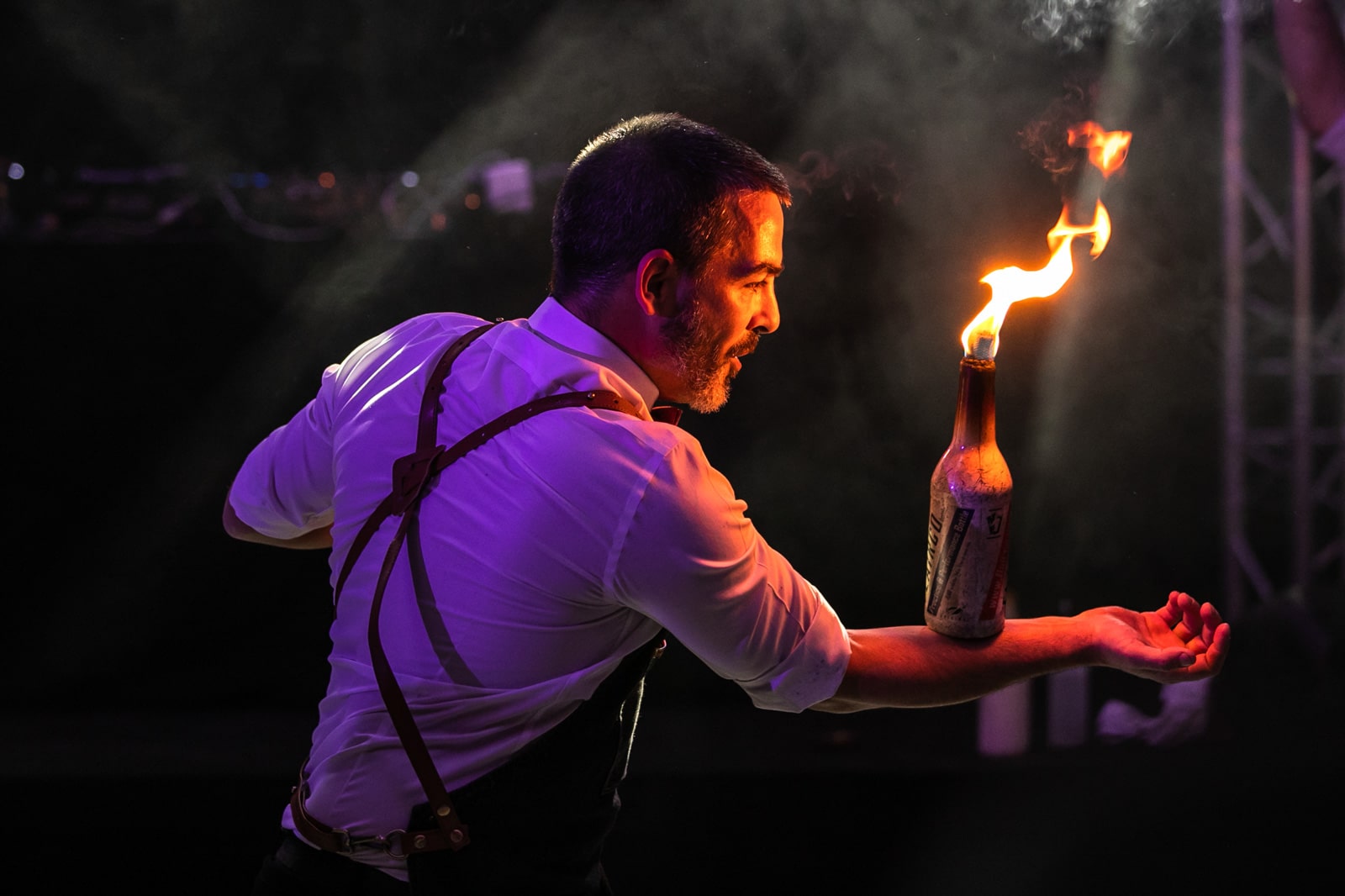 Photo d'un homme jonglant avec une bouteille enflammée