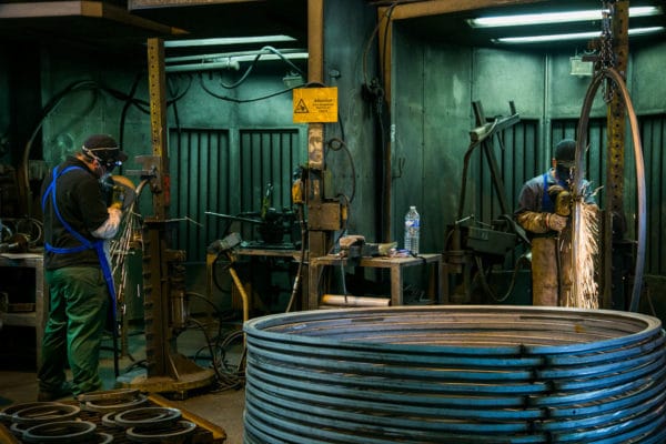 photographie d'opérateurs ébavurant des pièces de forge